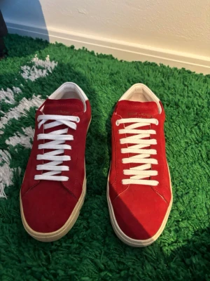 Saint Laurent Paris Röda Skor - Hej! Säljer nu dessa väldigt snygga Yves Saint Laurent Skor.  Storlek: 40. Färg: Röda och beiga.  Skick: Helt nya, endast testade.   Skickas spårbart eller hämtas upp efter överenskommelse. Vid intresse – hör gärna av dig.