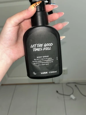 LUSH Let The Good Times Roll Body Spray - LUSH Let The Good Times Roll Body Spray är en kroppsspray med unik doft av smörig popcorn och sötma. Flaskan är svart med vit text och rymmer 200 ml. Enkel sprayfunktion och stilren design gör den smidig att använda och ha med sig.