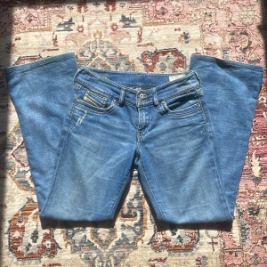 Blå diesel bootcut jeans med dubbla knappar - Lågmidjade blå bootcut jeans från diesel med dubbla knappar i midjan. Strl W28 L 32