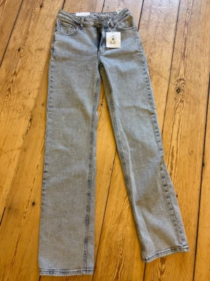 Ljusgrå raka jeans från Gina Tricot - Säljer ett par helt nya ljusgråa mid waist jeans med rak passform. Jeansen är perfekta till en avslappnad stil. Materialet är denim i bomull. Snygga att matcha med sneakers eller boots🤩W-26, L-32 Nypris:699