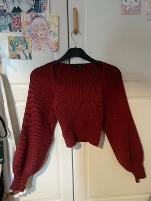 Mörkröd croppad stickad tröja Dazy - Snygg mörkröd croppad stickad tröja från Dazy med ribbad struktur och långa ballongärmar. Tröjan har en bred, fyrkantig ringning och sitter lite loose. Perfekt för dig som vill ha en trendig och bekväm look. Använd en gång, utan defekter. Ungefärligt pris är ~250kr, då jag inte har kvittot kvar och jag hittar den inte online längre. Säljer för 150kr. Sista bilden är en REFERENS inte exakta tröjan.