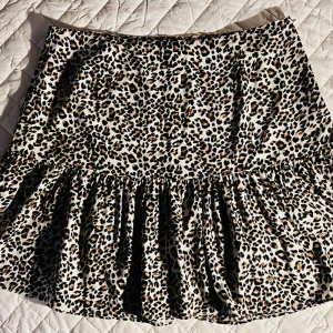 Trendig NLY Trend leopardkjol med volang stl 42 🐆✨ - Säljer denna supersnygga minikjol med leopardmönster från NLY Trend i storlek 42! Den stängs med en dold dragkedja i sidan för perfekt passform och har den helt rätta "frill"-volangen längst ner för en snygg Pinterest-look. Skönt material i 100% polyester som enkelt tvättas i 30 grader. Sitter superfint på, har ett härligt fall och passar till precis allt i sommar! Mått när den ligger platt: * Midja: ca 42 cm * Längd: ca 43–44 cm Ansvarar inte för postens slarv. Buda eller köp direkt via köpknap