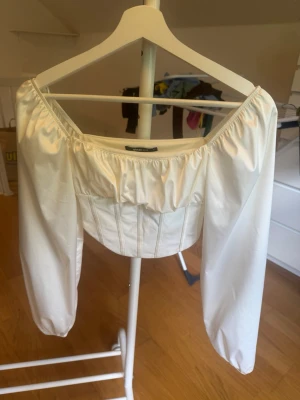 Vit korsettopp från Gina Tricot - Vit korsettopp från Gina Tricot stl 34. Toppen har en croppad passform och är i fint skick