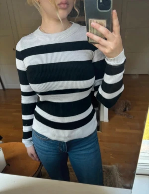 Lindex ribbad randig polotröja svartvit S – figurnära - Svartvit randig ribbad polotröja från Lindex i storlek S/36. Figurnära och stretchig modell som sitter väldigt fint på kroppen. Klassisk, tidlös och lättstylad tröja som passar perfekt till jeans, kjol, boots eller under blazer/kappa.• Märke: Lindex • Storlek: S / 36 • Färg: svart och vit • Modell: ribbad, randig, figurnära polotröja • Skick: mycket bra skick, se bilder • Stretchig och bekväm passform