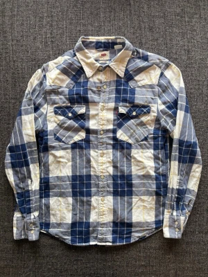 Levis skjorta ~ 2000’s modell - Sjukt eftertraktad Levi’s skjorta ~ 2000’s modell som inte längre produceras | st S/true size | Rekomenderad längd mellan 170–180cm | färg blå/vit | OBS kan gå ner lite i pris vid snabb affär! 🏄