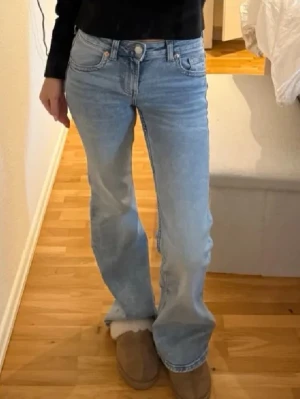 Ljusblå bootcut jeans med fickdetaljer - Säljer ett par ljusblå bootcut jeans med snygga fickdetaljer bak och knappstängning.