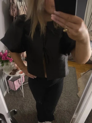 Svart croppad blus med puffärm - Snygg svart croppad blus med puffiga korta ärmar och knytning framtill. Pris kan självklart diskuteras!🩷☺️