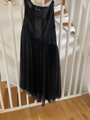Svart långklänning från H&M tyll Studio limited edition - Svart klänning i tyll från H&M Studio. Storlek L. Asymmetriskt skuren i både övergången mellan liv och kjol och i klänningens avslut.  Använd 1 gång, så nästintill nyskick.  🖤🖤🖤Magisk klänning till festen 🖤🖤🖤