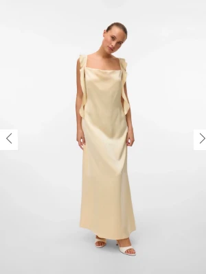 Gul satin klänning, Vera Moda  - Lång finklänning från Vera Moda, aldrig använd med prislapp kvar! Perfekt i längd på mig som är 168cm lång.