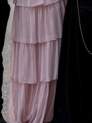 Ljusrosa volangklänning  - Säljer en långklänning i ljusrosa med flera lager volanger. Klänningen har en romantisk och flowy känsla, perfekt för dig som gillar en feminin stil. Tillverkad i ett tunt, lätt material som ger ett snyggt fall.