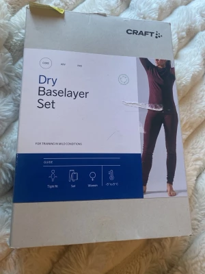 Craft Dry Baselayer Set dam - Säljer ett mörklila/rött underställsset från Craft för damer. Setet består av långärmad tröja och långa tights i tight passform, perfekt för träning i milda temperaturer (+5 till -5°C). Materialet är 100% återvunnen polyester som transporterar bort fukt. Det är helt nytt och aldrig använt, storleken är S i båda delarna och den kostar från 550kr-600kr ny.