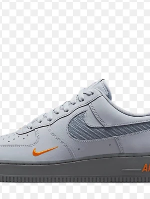 Nike Air Force 1 grå/orange sneakers - Nike Air Force 1 sneakers i ljusgrått läder med grå mesh-detaljer på swoosh-loggan. Skon har orange detaljer på swoosh och AIR-trycket på sulan. Klassisk siluett med perforerad tå och grå yttersula. Perfekt för dig som gillar stilrena men ändå unika sneakers.