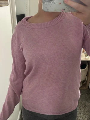 Ljusrosa stickad tröja - Mysig ljusrosa stickad tröja med rund halsringning och ribbade muddar vid ärmslut och nederkant. Tröjan har en enkel och stilren design som passar perfekt till jeans eller kjol. Materialet känns mjukt och bekvämt mot huden. Använd fåtal gånger så fint skick, inte nopprig