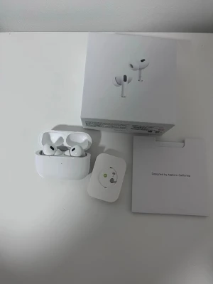 Apple AirPods Pro trådlösa hörlurar - Säljer ett par vita Apple AirPods Pro med laddningsetui. De är trådlösa in-ear-hörlurar med silikontoppar och stilren design. Kommer med originalförpackning och tillbehör. Perfekta för musik, samtal och träning.