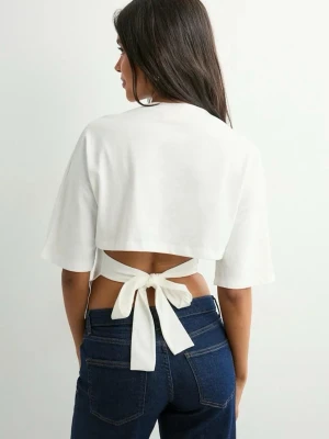 Nelly  topp med knyt i ryggen🤍 - Snygg vit croppad topp med kort ärm och knyt i ryggen. T-shirten har en enkel och stilren design, perfekt för att skapa en trendig look. Tillverkad i mjukt bomullstyg som känns skönt mot huden. T-shirten är från Nelly och kommer se utrolig ut i sommar☀️☀️
