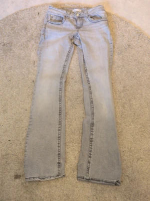 Ljusgråa bootcut jeans - Svårborttagen fläck på baksidan, se sista bilden, kan hämtas i skåne