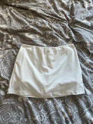 Vit kort kjol - Vit minikjol med inbyggda short. Aldrig använd!