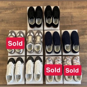 Flera sneakers i olika färger - Samling av Maison Margiela sneakers i olika färger och mönster. Här finns klassiska modeller i svart, marinblått, grått och vitt samt varianter med färgstänk och svartvitt mönster. Alla sneakers har lågt skaft och är tillverkade i läder och mocka.