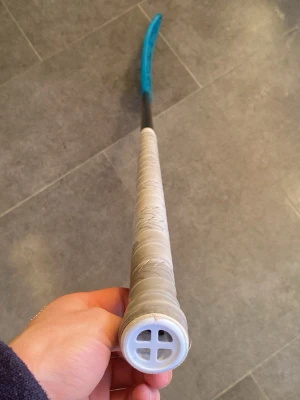 Ny zone Innebandyklubba med blått blad 94 cm  - Säljer en innebandyklubba med svart skaft, vitt grepp och ett blått plastblad. Klubban har ett klassiskt utseende och greppet är lindat med vit tejp. Perfekt för dig som gillar innebandy och vill ha en snygg klubba. Säljer en zone klubba helt ny