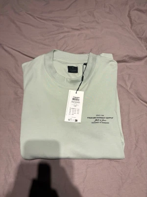 Ljusgrön t-shirt från Jack & Jones - Snygg ljusgrön t-shirt från Jack & Jones med rund halsringning och tryck på bröstet. Enkel och stilren design, perfekt till jeans eller shorts. Tillverkad i mjuk bomull för skön känsla hela dagen.