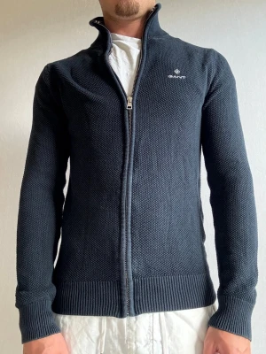 Gant kofta XS - Välkommen till byTorén Detta är en kofta från GANT i storlek XS med normal passform, dock mer åt slim hållet. Plagget är i bra skick men har tappat lite färg, se bilder. Hör av dig vid intresse eller frågor, vi hörs!