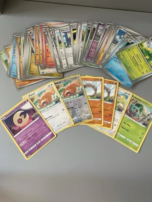 Samling Pokémonkort blandade motiv - Säljer en samling Pokémonkort med olika motiv som Bulbasaur, Charmander, Squirtle, Eevee och fler. Korten har färgstarka illustrationer och varierande bakgrunder. Perfekt för dig som gillar att samla eller spela Pokémon TCG.