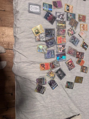 Samling Pokémon - Stor samling med Pokémonkort och men även flera med holografisk effekt och olika motiv. Blandade färger och karaktärer, vissa kort i plastfickor för extra skydd. Perfekt för dig som gillar att samla ell