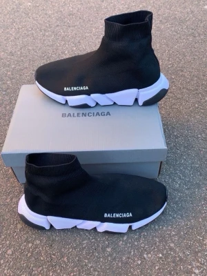 Balenciaga Speed Trainer svarta sneakers - Svarta Balenciaga Speed Trainer sneakers med vit chunky sula och stickad strumpdesign. Skorna har Balenciaga-logga på sidan och är tillverkade i stretchigt textilmaterial för en tight och bekväm passform.