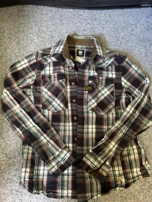 Rutig skjorta från G-Star RAW - Hej! Säljer en riktigt fet G-star skjorta. Den är fet att bära som en vanlig skjorta men personligen föredrar jag att använda den som en typ av overshirt. Det är en storlek large men sitter som en M. Tveka inte på att höra av dig vid intresse🙌🙌