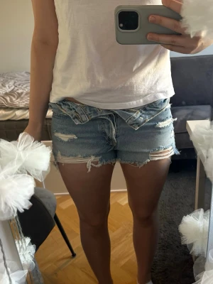 Ljusblå jeansshorts - Ett par superfina ljusblå jeansshorts med slitna detaljer från Zara😍Kan användas högmidjade som de är eller vika ner dem som jag gjort på bilden (vilket är lätt med knapparna som gör att det sitter bra). Säljer då de tyvärr blivit lite för små för mig