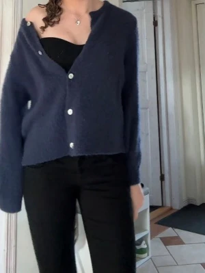 Mörkblå fluffig kofta med knappar - Mysig mörkblå kofta med fluffig textur och vita knappar framtill. Koftan är lite nopprig och använd. Orginalpriset är 599kr❤️‍🔥