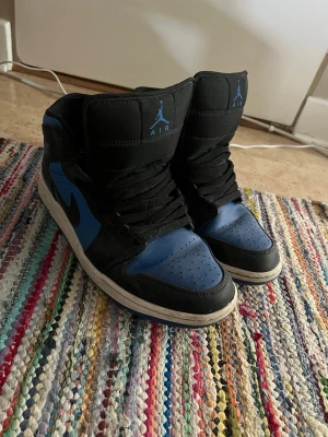 Air Jordan 1 Mid Black Royal Blue - Äkta blåa Jordan 1 som inte går att köpa längre (köpta i 2024) de är storlek 44 fast passar även mig bra som är storlek 42-43   Ifall du har några frågor så är de bara att skriva jag är aktiv och skickar iväg snabbt. Priset kan diskuteras 