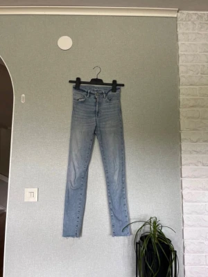 Ljusblå skinny jeans XS - Säljer ett par ljusblå skinny jeans i storlek XS. Jeansen har klassisk femficksdesign, hög midja och smala ben. Perfekta till vardagsstilen och lätta att matcha med olika toppar. Materialet är denim i bomull med lite stretch för extra komfort.
