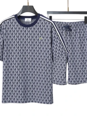 Mönstrad pyjamas från Lacoste - Snygg tvådelad pyjamas från Lacoste i marinblått och vitt med grafiskt mönster. T-shirten har rund hals, korta ärmar och vita ränder på axlarna. Shortsen har dragsko i midjan. Materialet känns mjukt och andas bra. Klassisk Lacoste-logga på bröstet.