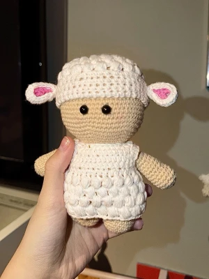 Virkad söt lammfigur - Handgjord virkad lammfigur i beige och vitt garn med rosa detaljer i öronen. Figurer har svarta säkerhetsögon och fluffig struktur på kroppen och mössan. Virkad med bomullsgarn.
