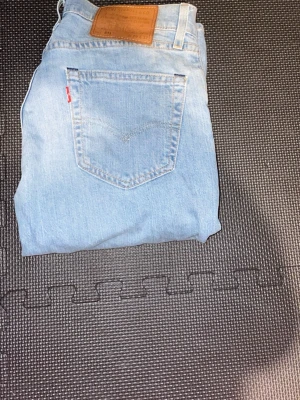 Ljusblå Levi's 511 jeans - Säljer ett par ljusblå Levi's 511 jeans i klassisk rak modell. Jeansen har fem fickor, Levi's ikoniska röda etikett på bakfickan och patch i läder bak i midjan. Tillverkade i mjuk denim som ger en avslappnad vibe. w29 l32