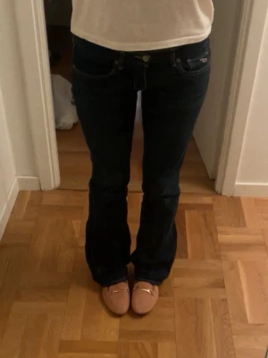 Mörkblå bootcut jeans - Säljer ett par lågmidjade mörkblå bootcut jeans från hollister. Materialet är strechigt denim som håller formen. Storlek W27L31. Jag är 165cm lång