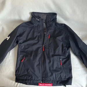 Helly Hansen jacka - Vind/seglingsjacka från helly hansen, passar storlek M. Den är mörkblå och i fint skick, står dock obs bygg på ärmen men går att ta bort om man skulle vilja.