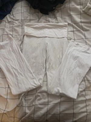 Vita leggings med hög midja - Säljer ett par vita leggings med hög midja och bred linning. De är mjuka och stretchiga, perfekta för en avslappnad stil. Passar dig som gillar enkel och clean look.