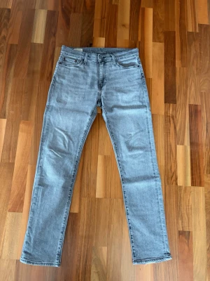 Ljusgrå jeans Levis 511 slim fit - Säljer ett par ljusgrå jeans från Levi's med klassisk femficksdesign. Jeansen har en diskret tvättad look och Levi's ikoniska röda etikett bak. Perfekta till en avslappnad stil och passar till det mesta. De kostar ny pris 1200 men säljer nu för 400