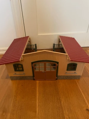 Schleich stall - Fint schleich stall, kommer med vattenkopp, krubba med äpplen och sadel och tränshängare till alla boxar. Har lite klistermärken i ena boxen