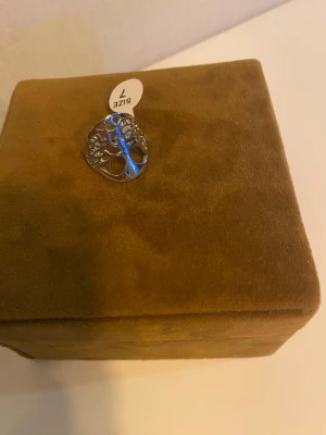 Silverring med livets träd motiv - Snygg silverfärgad ring med ett detaljerat motiv av livets träd. Ringen har en rund form och är öppen i designen vilket ger en modern känsla. Perfekt accessoar för dig som gillar naturinspirerade smycken.