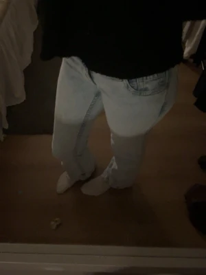Ljusblåa  jeans - Säljer ett par ljusblå jeans med  klassisk femficksdesign. Jeansen är utsvängda nere vid benen, och inte för höga i midjan. Perfekta för en avslappnad och trendig look.