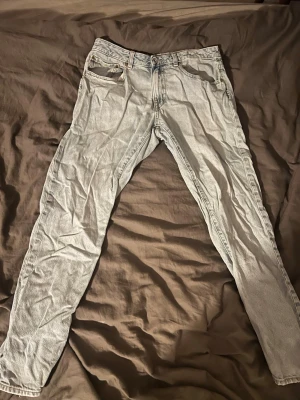Ljusblå raka jeans vailent large - Säljer ett par ljusblå jeans med rak passform och klassisk femficksdesign. Jeansen har bälteshällor. Materialet är denim i bomull och färgen är tvättad ljusblå, perfekt för en avslappnad stil. Litet håll i insidan på högerfickan. 