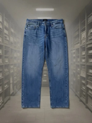 Blå tapered jeans Tapered/Mike - Snygga blå jeans med tapered fit från Tapered/Mike. Klassisk femficksmodell med dragkedjegylf och raka ben. Tillverkade i slitstark denim som ger en avslappnad men ändå stilren look. Perfekta för dig som gillar en modern passform.