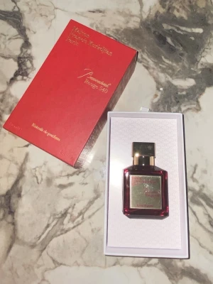 Baccarat Rouge 540 Extrait de Parfum 70ml - Lyxig parfym från Maison Francis Kurkdjian, Baccarat Rouge 540 Extrait de Parfum. Flaskan är elegant i rött glas med gulddetaljer och matchande röd ask med guldfärgad text. Innehåller 70 ml. Perfekt för dig som vill ha en exklusiv och unik doft.