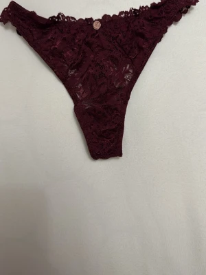 Vinröda spets-trosor med blomdetaljer - Oanvända string trosor i storlek XS