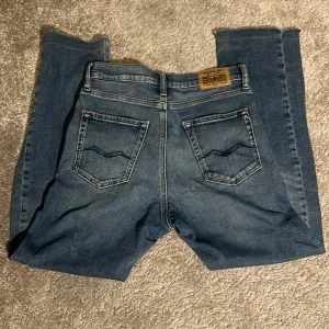 Blå Replay jeans Thad straight fit - Säljer ett par blå jeans från Replay, modell Thad. Klassisk med raka ben och snygga detaljer på bakfickorna. Jeansen har normal passform och är tillverkade i slitstarkt denimtyg. Perfekta för dig som gillar en avslappnad stil.