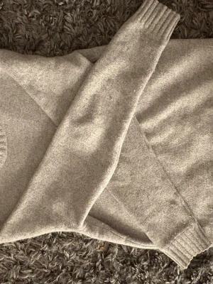 Stickad tröja  - En snygg grå stickad tröja från EAST WEST i lambswool. stilren tröja till vardags/ perfekt nu till våren/sommarkvällarna. Nypris 899. Skriv vid minsta lilla fundering storlek S/M