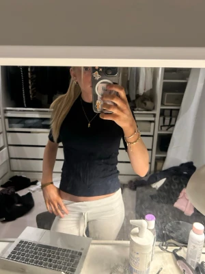 Svart tight t-shirt i bomull - En enkel och stilren svart t-shirt med tight passform och korta ärmar. Tillverkad i mjuk bomull som sitter skönt mot kroppen. Perfekt att matcha med jeans eller kjol för en clean look.